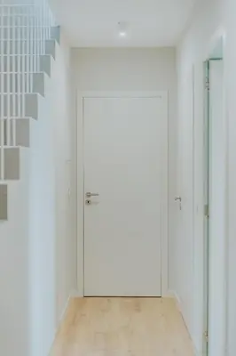 a hallway with white doors and a staircase at Mango House in Arco da Calheta