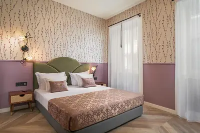a bedroom with a large bed and a wall with wallpaper at Madeira Gems Apartments in Funchal