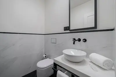 a bathroom with a sink and a toilet and a mirror at Madeira Gems Apartments in Funchal