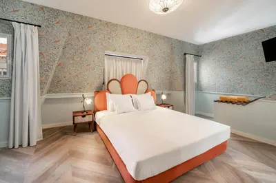 a bedroom with a large white bed with an orange headboard at Madeira Gems Apartments in Funchal