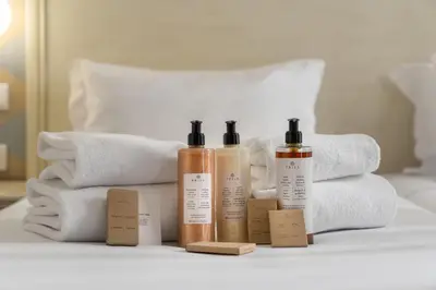 a group of four bottles of soap and towels on a bed at Madeira Gems Apartments in Funchal