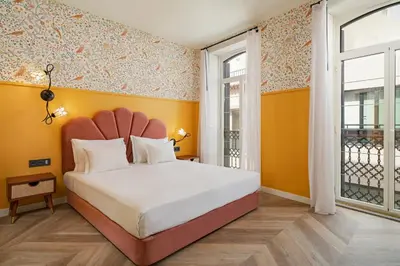 a bedroom with a large bed with yellow walls at Madeira Gems Apartments in Funchal