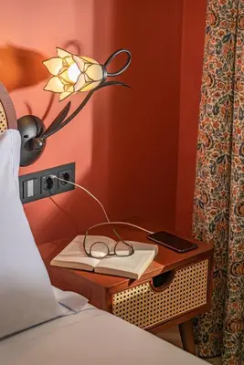 a bedside table with a lamp and a book at Madeira Gems Apartments in Funchal