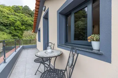 a patio with a table and chairs on a balcony at Ilha Natura in Santana