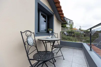a patio with two chairs and a table on a balcony at Ilha Natura in Santana