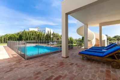 a patio with a swimming pool and blue lounge chairs at Villa Ocean Blue in Sagres