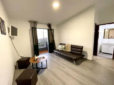 a living room with a couch and a table at Sunset Star with Sea View in Calheta