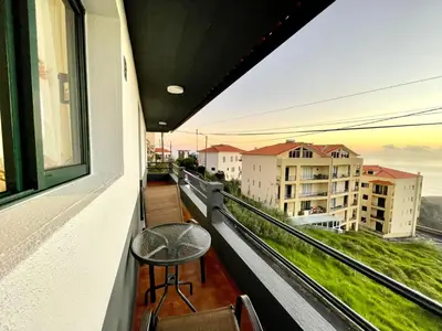 a balcony with a table and a view of the ocean at Sunset Star with Sea View in Calheta