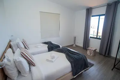 a bedroom with two beds and a large window at Sunset Star with Sea View in Calheta