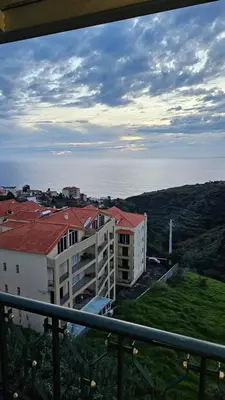 a view from a balcony of a building and the ocean at Sunset Star with Sea View in Calheta