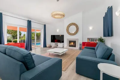 a living room with two blue couches and a fireplace at Beach Villa - oceanfront villa Martinhal in Sagres