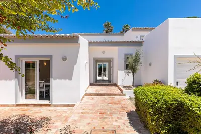 a white house with a brick walkway at Beach Villa - oceanfront villa Martinhal in Sagres