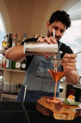 a man is making a drink in at NEXT - by Savoy Signature in Funchal