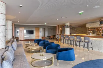a lobby with blue chairs and tables and a bar at NEXT - by Savoy Signature in Funchal