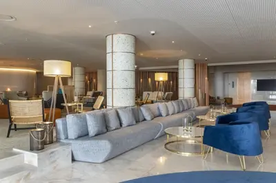 a living room with a large couch and blue chairs at NEXT - by Savoy Signature in Funchal