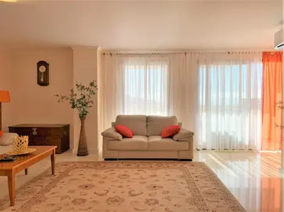 a living room with a couch and a table at Charming Calheta Plaza Penthouse in Calheta