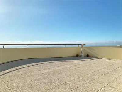 a person standing on a balcony looking at the ocean at Charming Calheta Plaza Penthouse in Calheta