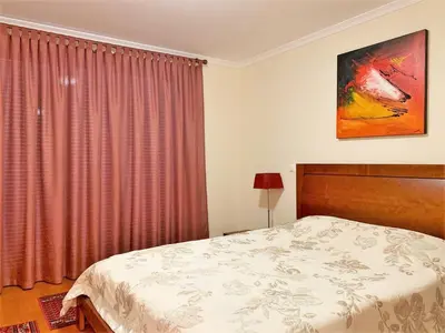 a bedroom with a bed and a red curtain at Charming Calheta Plaza Penthouse in Calheta
