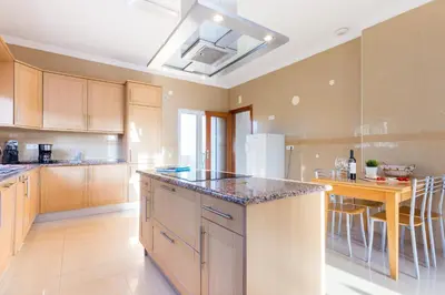 a kitchen with wooden cabinets and a counter top at CoolHouses Algarve Luz, 5 bed villa & pool, Casa N in Luz