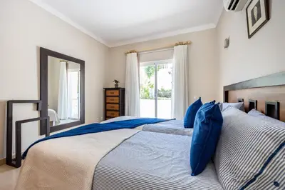 a bedroom with two beds with blue pillows at CoolHouses Algarve Luz, 5 bed villa & pool, Casa N in Luz