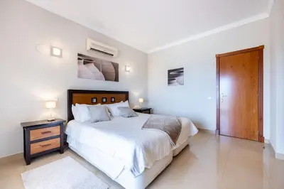 a white bedroom with a bed and a wooden door at CoolHouses Algarve Luz, 5 bed villa & pool, Casa N in Luz