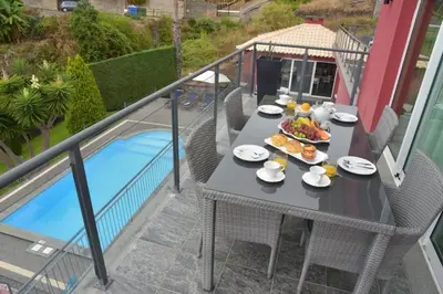 a table with plates of food on a balcony at Quinta do Brasil in Arco da Calheta