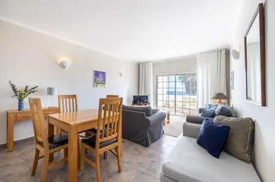 a living room with a table and a couch at CoolHouses Algarve Luz, 1 bed penthouse flat w/ sea views. Fiji 11 in Luz