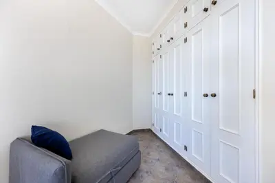 a living room with a couch and a closet at CoolHouses Algarve Luz, 1 bed penthouse flat w/ sea views. Fiji 11 in Luz