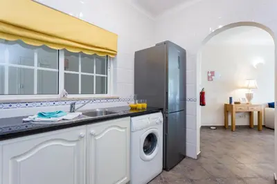 a kitchen with a washing machine and a sink at CoolHouses Algarve Luz, 1 bed penthouse flat w/ sea views. Fiji 11 in Luz