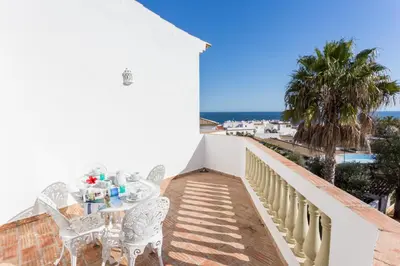 a balcony with a table and chairs and a view of the ocean at CoolHouses Algarve Luz, 1 bed penthouse flat w/ sea views. Fiji 11 in Luz