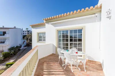 a patio with a table and chairs on a balcony at CoolHouses Algarve Luz, 1 bed penthouse flat w/ sea views. Fiji 11 in Luz