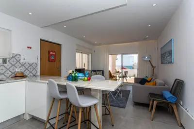 a kitchen and living room with a table and chairs at Lemon Tree Apartment in Luz