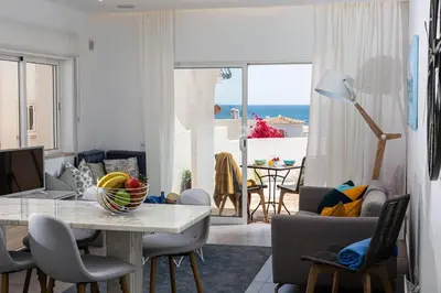 a living room with a table and a view of the ocean at Lemon Tree Apartment in Luz