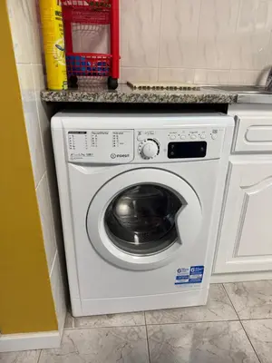 a white washing machine in a kitchen next to a counter at Casa 212 in Ponta do Sol