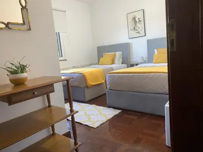 a bedroom with two beds and a table and a table sidx sidx sidx at Casa 212 in Ponta do Sol