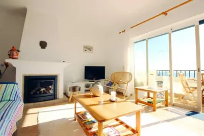 a living room with a table and a fireplace at Bright and central apartment - Praia da Luz in Luz