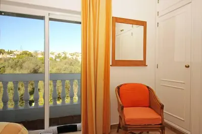 an orange chair in a room with a window at Bright and central apartment - Praia da Luz in Luz