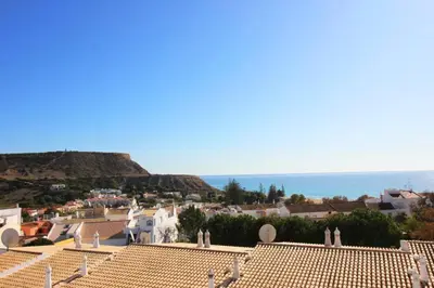 a view of a town with the ocean in the background at Bright and central apartment - Praia da Luz in Luz