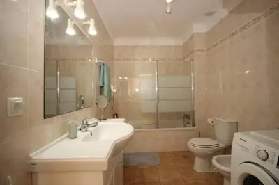 a bathroom with a sink and a toilet and a mirror at Bright and central apartment - Praia da Luz in Luz