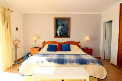 a bedroom with a large bed with blue and red pillows at Bright and central apartment - Praia da Luz in Luz