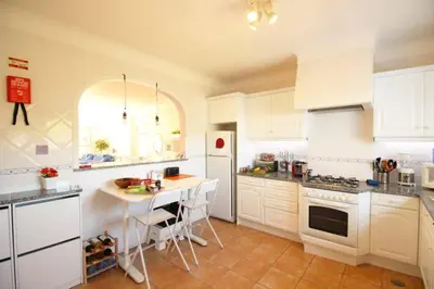 a kitchen with a table and a white refrigerator at Bright and central apartment - Praia da Luz in Luz