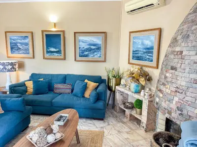 a living room with a blue couch and a fireplace at Casa Canavial in Lagos