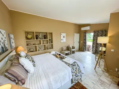 a bedroom with a large bed and a living room at Casa Canavial in Lagos