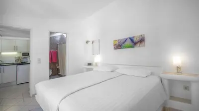 a white bedroom with a white bed and a kitchen at Sunny Seaside 1 bedroom apartment in Praia da Luz in Luz