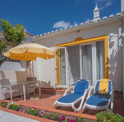 a pair of chairs and an umbrella on a patio at Sunny Seaside 1 bedroom apartment in Praia da Luz in Luz