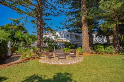 a yard with two benches and a house at Sunny Seaside 1 bedroom apartment in Praia da Luz in Luz