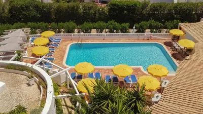 an overhead view of a swimming pool with chairs and umbrellas at Sunny Seaside 1 bedroom apartment in Praia da Luz in Luz