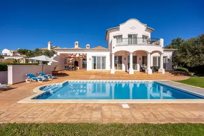 a villa with a swimming pool in front of a house at Casa Gribouille in Sagres