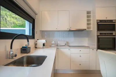 a white kitchen with a sink and a window at CASA GEORGINA in Calheta