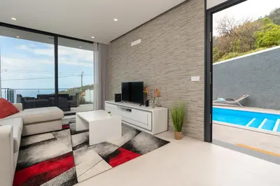 a living room with a couch and a tv at CASA GEORGINA in Calheta